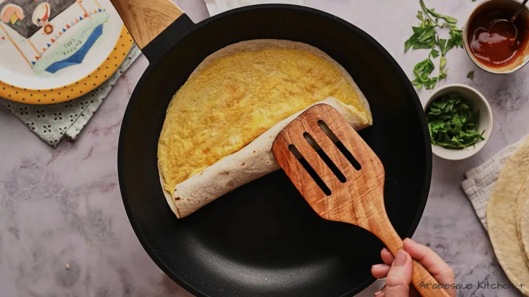Cover with a wheat wrap and allow for the cheese and egg to stick to the wrap, pressing it a bit with your hands.