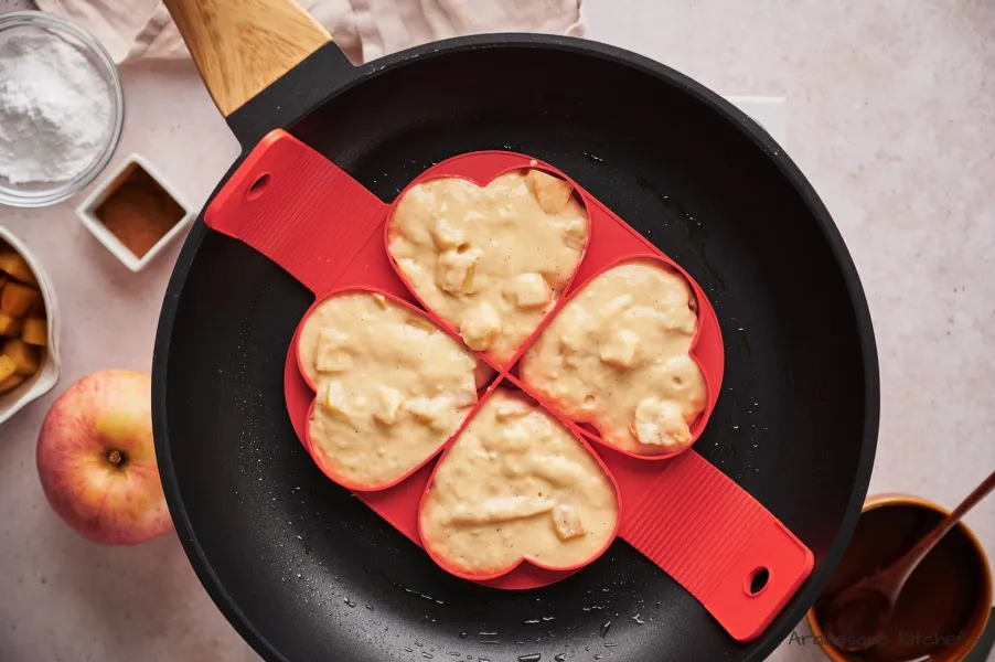 Grease a non-stick skillet with cooking spray and place your shaped silicone molds.
