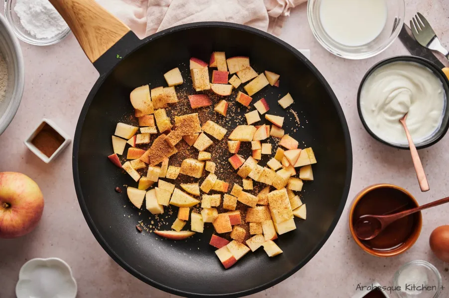 Chauffer une poêle antiadhésive à feu moyen et ajouter les pommes, saupoudrer de cannelle en poudre et de cassonade.