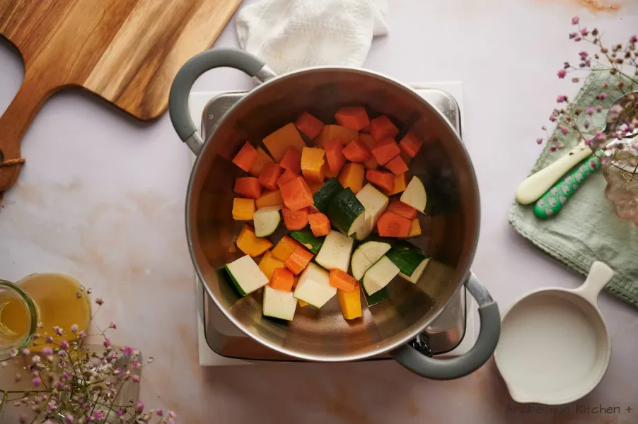 Chauffer une casserole profonde à feu moyen-vif et ajouter l'huile d'olive. Une fois chaude, ajouter la courge musquée, la courgette et la carotte.