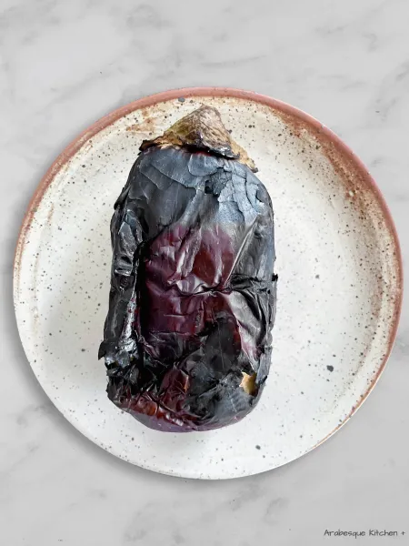 Carefully place the aubergines directly over an open flame and roast for 15 minutes, turning occasionally with the aid of tongs until the skin is scorched all over and the flesh feels tender.