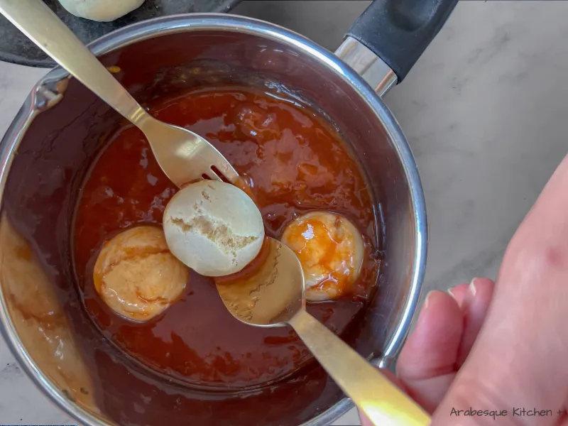 Faites chauffer la confiture et l'eau de fleur d'oranger dans une petite casserole pendant 3 minutes jusqu'à ce que le mélange soit chaud et collant. Trempez délicatement les gâteaux dans la confiture chaude pendant 10 à 20 secondes. Utilisez une fourchette et une grande cuillère pour rouler les boules de pâte dans la noix de coco déshydratée. Transférez les boules de pâte dans une grande assiette. Laissez refroidir à température ambiante avant de servir. 