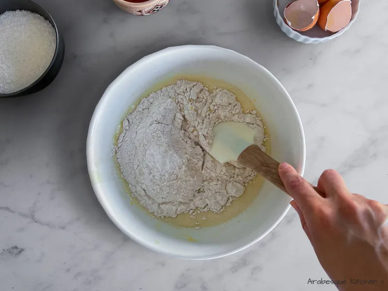 Ajoutez la farine et la levure chimique et utilisez une spatule ou vos mains pour mélanger tous les ingrédients ensemble jusqu'à obtenir une pâte lisse. Si votre pâte est trop molle, ajoutez quelques cuillères à soupe de farine.