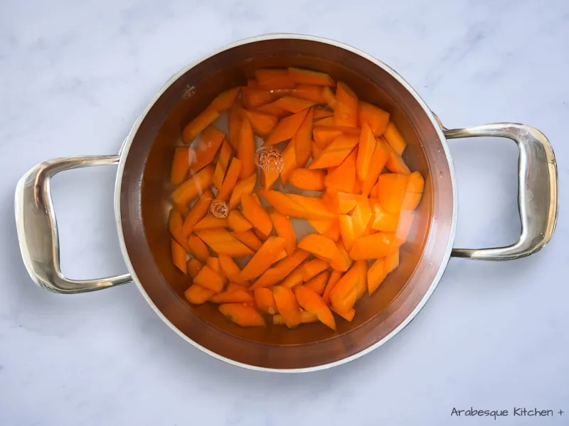 In a medium-sized pan, bring water to a boil and add the carrots “peeled and chopped into 2cm pieces”. Reduce the heat to medium and cook the carrots until lightly crisp and tender, about 10 to 20 minutes depending on the size of your chopped carrots. Drain, rinse under cold water, and drain again. Set aside. 
