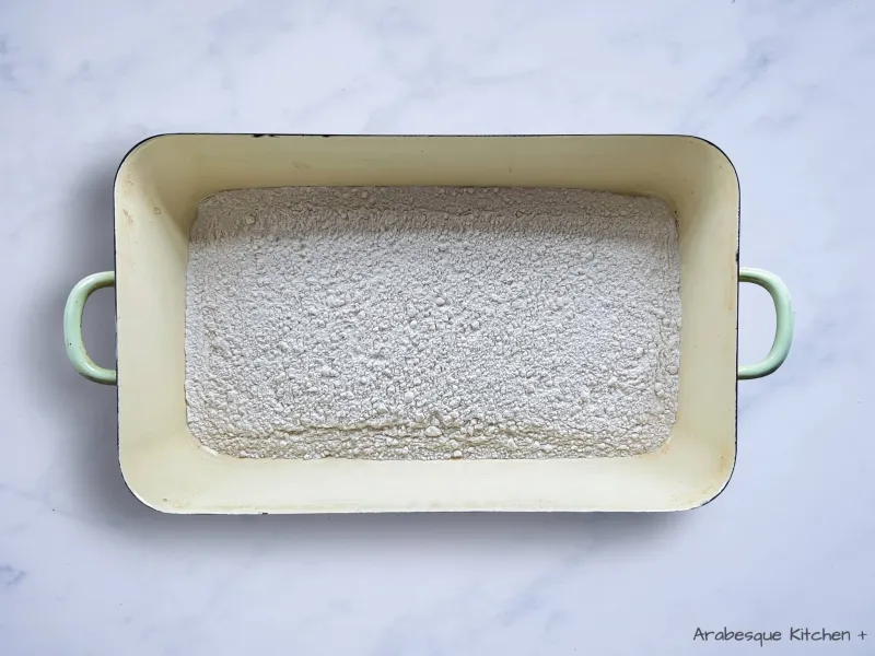 Étalez la farine dans un moule à rôtir et faites rôtir pendant 45 minutes ou jusqu'à ce qu'elle soit légèrement dorée et devienne jaune pâle, en la remuant bien toutes les 15 minutes pour vous assurer qu'elle rôtisse uniformément.