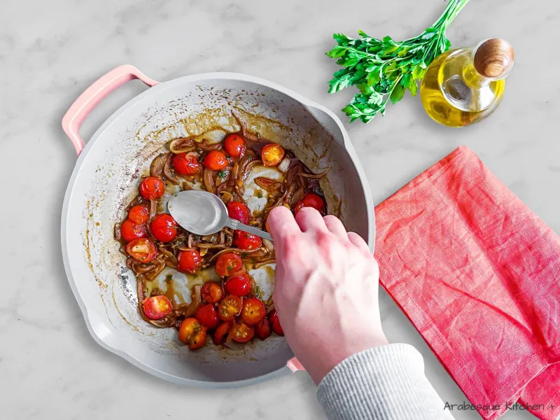 Utilisez une grande cuillère pour faire de la place pour les œufs. Cassez les œufs directement dans la sauce aux tomates cerises et aux oignons, couvrez à nouveau la casserole et faites cuire pendant environ 6 minutes jusqu'à ce que les blancs soient pris mais que les jaunes soient encore liquides. 