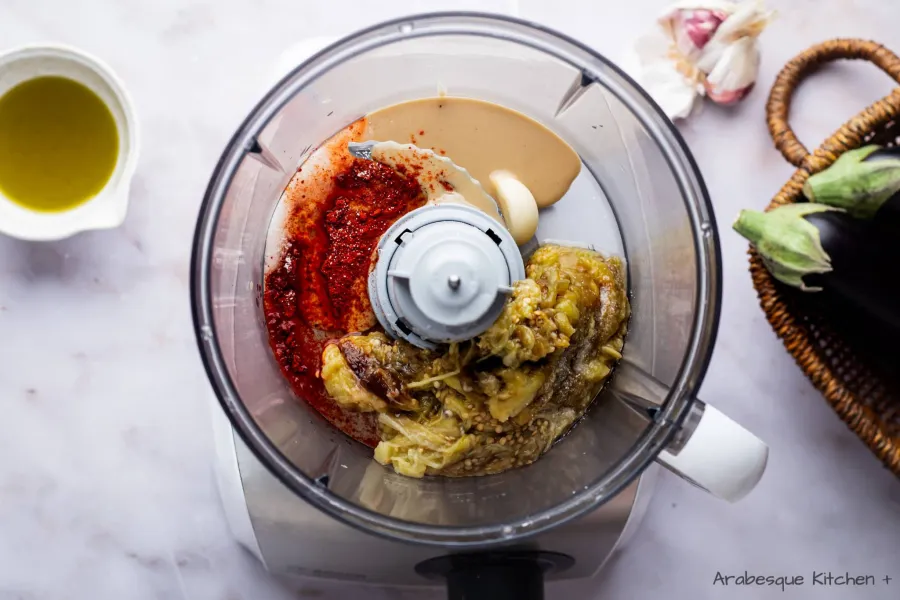 Dans un robot culinaire, ajouter les gousses d'ail et le jus de citron, le tahini, l'huile d'olive et le sel.