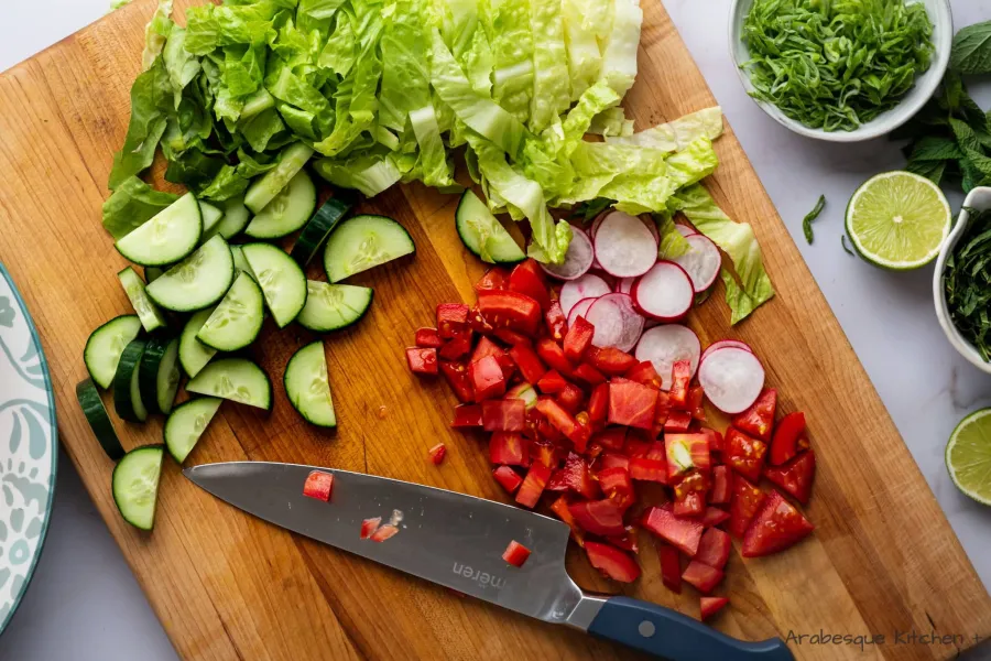 Chop the Romaine lettuce, English cucumber, Roma tomatoes and radishes.