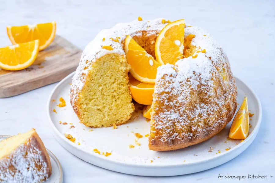 Slice and decorate with powdered sugar and orange zest strips.