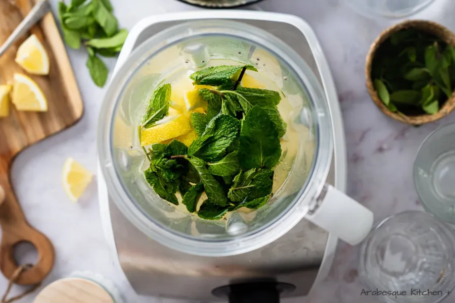 Mélanger les citrons, le jus de citron, les feuilles de menthe, le sucre et l'eau dans un mélangeur et mélanger jusqu'à ce que le tout soit bien mélangé.
