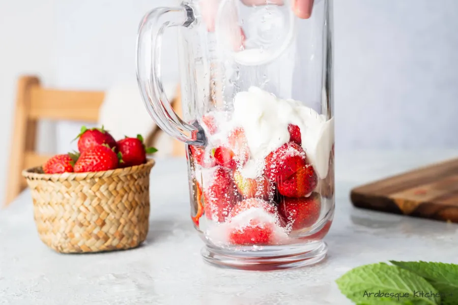Placer les fraises, le jus de citron, le yogourt grec, le sucre et la glace pilée dans un vase mélangeur ou un robot culinaire. Traiter jusqu'à consistance lisse.