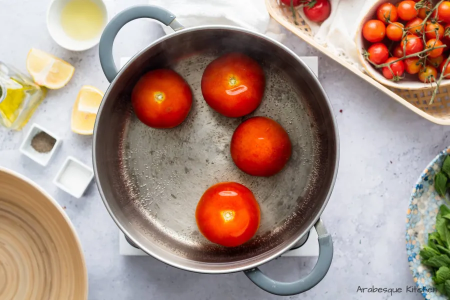 Portez une grande casserole d'eau à ébullition et ajoutez les tomates. Laissez-les cuire 3 à 5 minutes et retirez-les.
