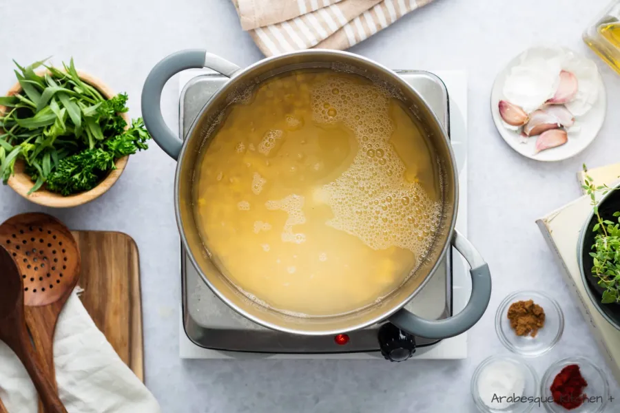 Placez les pois cassés, l'ail et l'eau dans une casserole profonde et faites chauffer jusqu'à ce qu'ils commencent à bouillir. Une fois que vous atteignez ce point, baissez le feu à moyen et laissez-les mijoter pendant 30 minutes (si elles sèchent, ajoutez un peu d'eau).