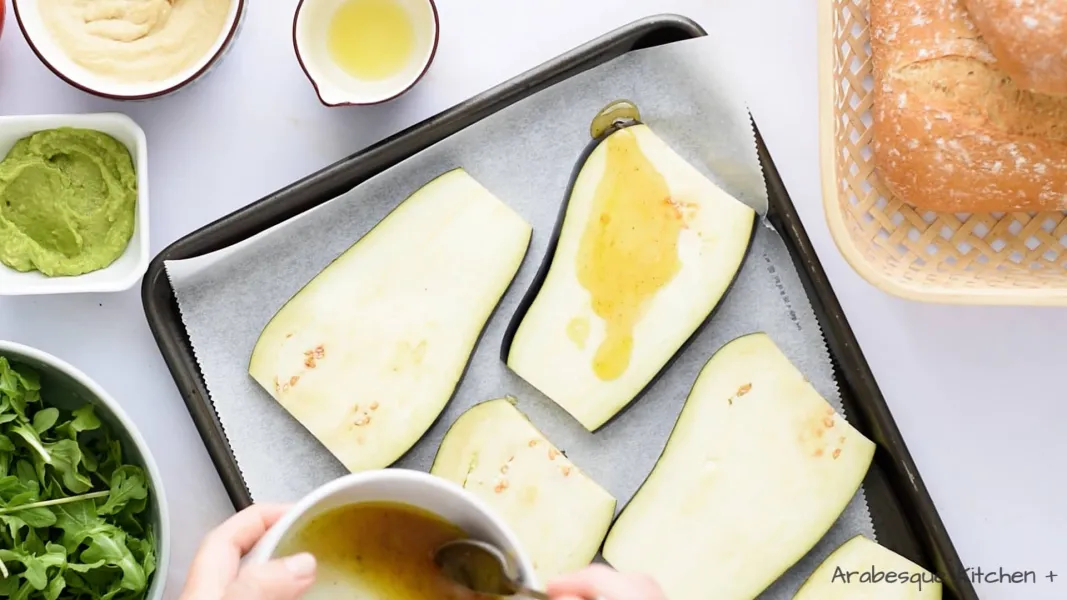 Line a baking tray with baking paper, arrange the eggplant slices and brush them with the sauce. Place in the oven and bake for 20 minutes, or until golden brown.
