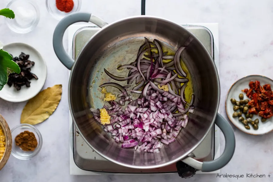 Faire chauffer une casserole à feu moyen et ajouter l'huile d'olive. Une fois chaud, ajouter les échalotes, l'oignon et les gousses d'ail.
