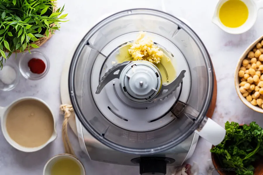 Mixez l'ail et 2 c. l'huile d'olive dans un robot culinaire jusqu'à consistance crémeuse ou jusqu'à ce que les morceaux soient très petits.