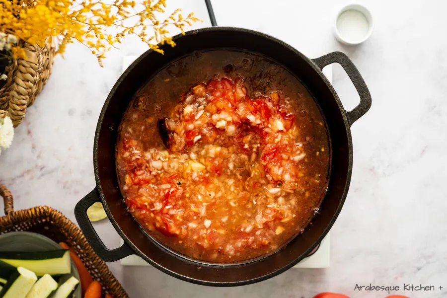 Ajouter les épices, la pâte de tomate et mélanger jusqu'à ce qu'ils soient bien mélangés. Ajouter le mélange de tomates et 200 ml. de bouillon de poulet et feuille de laurier.