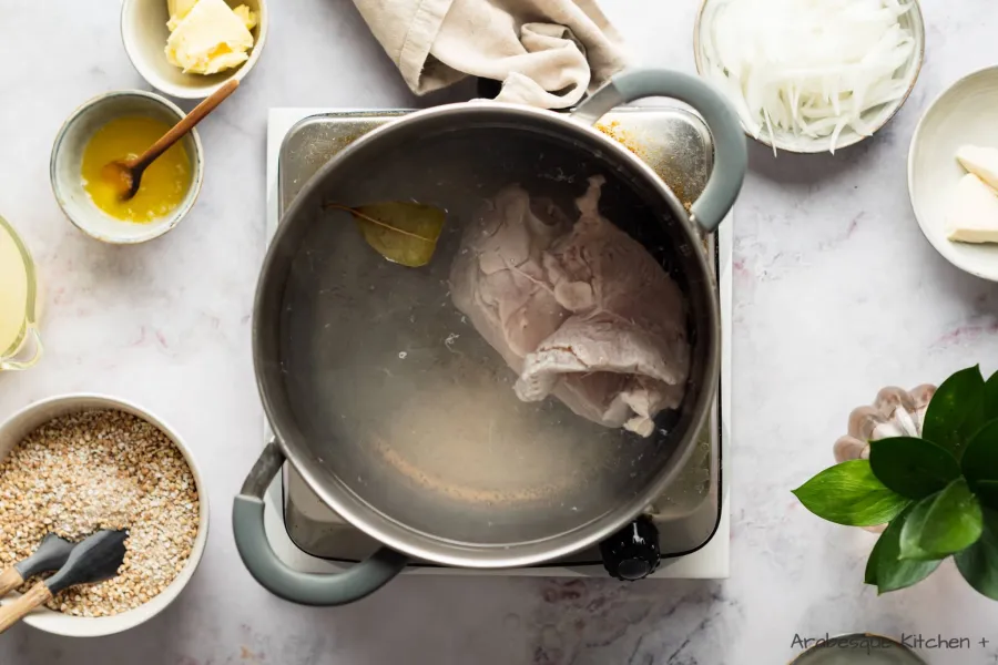 Porter une casserole d'eau à ébullition et ajouter la poitrine de poulet, la feuille de laurier et le sel. Porter à ébullition et cuire 20 minutes.